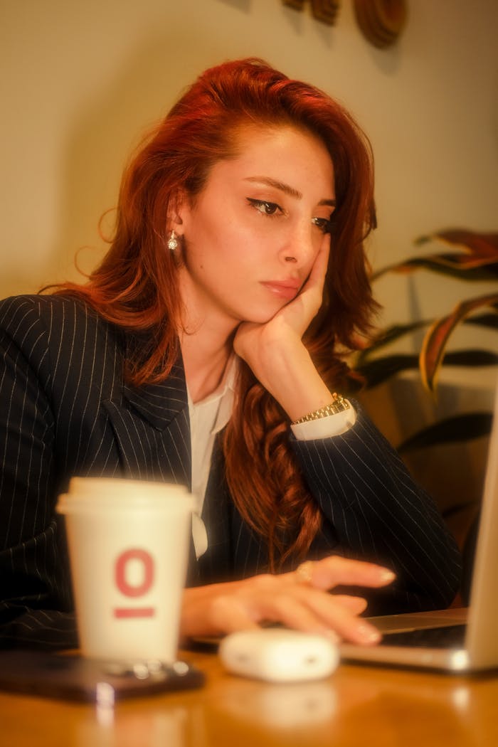 why-choose-us Portrait of a businesswoman working on a laptop with a cup of coffee on the table.